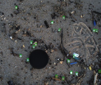 Beach photograph with green hand-drawn boxes marking each piece of microplastic waste